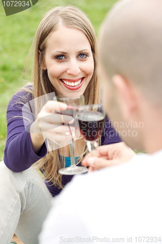 Image of Young romantic couple celebrating with wine