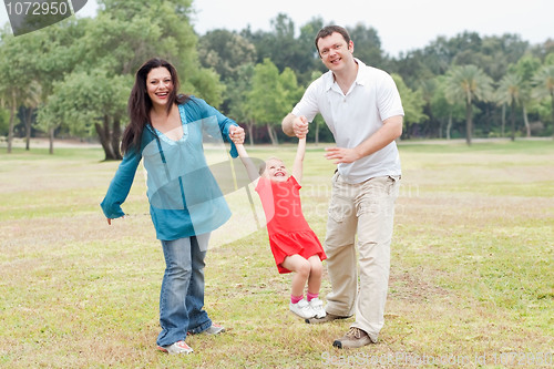 Image of Happy couple playing on the green park with their beautiful daughter