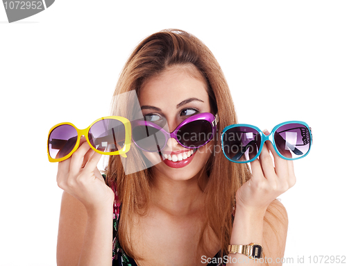 Image of young smiling woman holding different colors of sun glasses