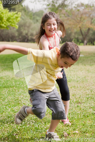 Image of Brother pulling his sister in the park