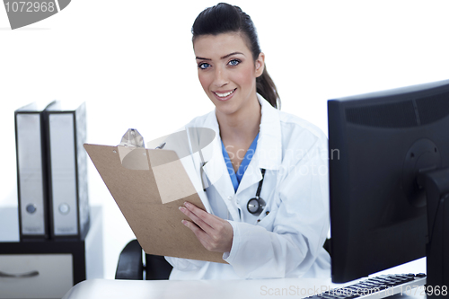 Image of Smiling young doctor with clipboard in hand looking at the camera