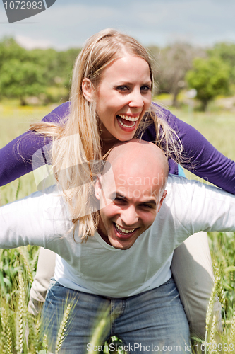 Image of Happy cute woman being piggy backed by her boyfriend