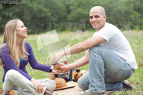 Image of Couple sitting in blanket smiling with picnic mode