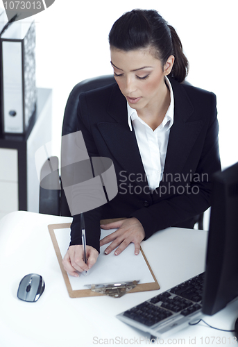 Image of Busy business lady making her notes on the clipboard