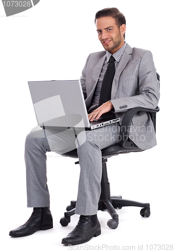 Image of Business man sitting with laptop and smiling