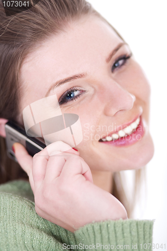 Image of Smiling beautiful girl speaking over cell phone