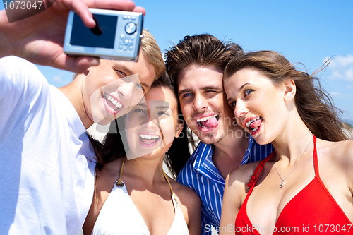 Image of Group of young friends standing together taking a self portrait