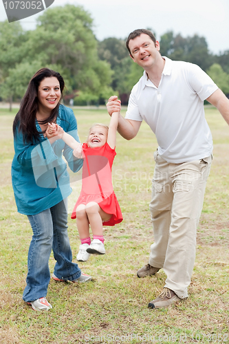 Image of Lovely couples playing with their happy daughter at the park