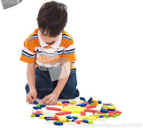 Image of Adorable caucasian boy joining the blocks while playing