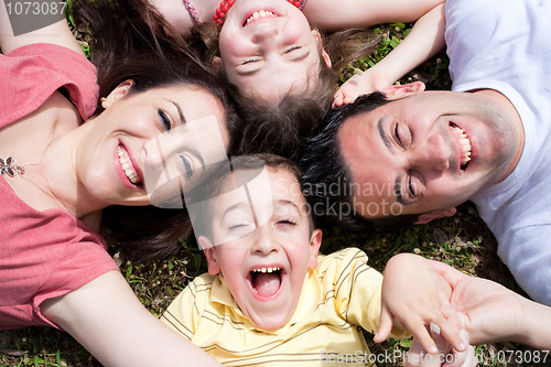 Image of Parents and kids laying on the floor with heads together