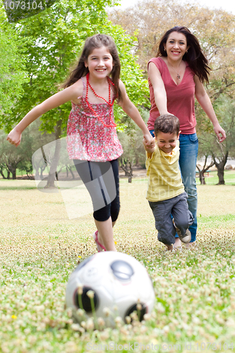 Image of Childrens playing football with their mother