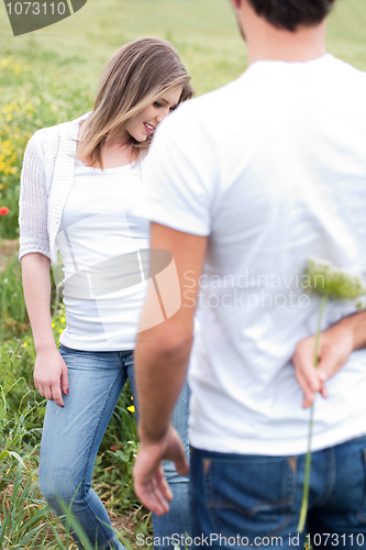 Image of Rear view of a boyfriend hiding a flower