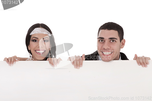 Image of Newly married couple standing behind the board