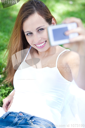 Image of Smiling young woman taking self portrait