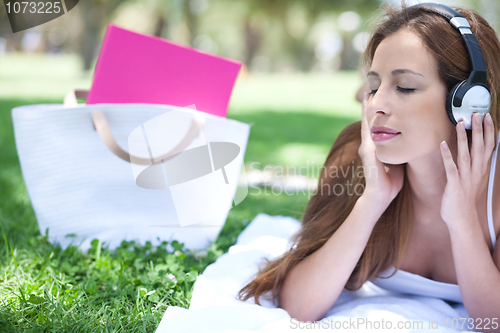 Image of Graceful women listening music with hand bag