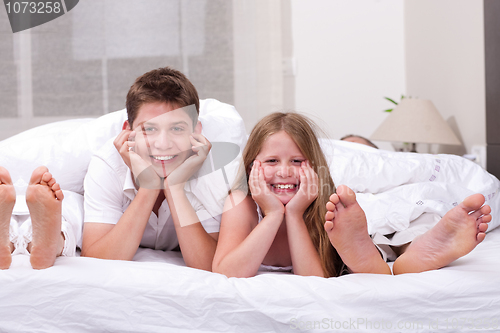 Image of Loving Brother and sister lying and having fun on the bed