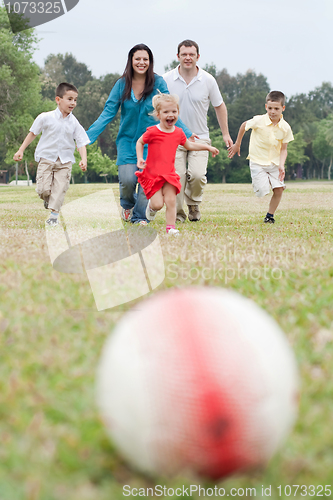 Image of Happy family of five having outdoors and playing soccer