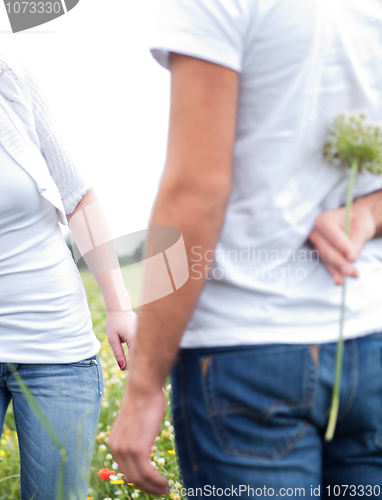 Image of Close up shot of a boyfriend hiding a flower