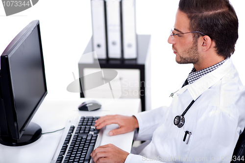 Image of male doctor working with desktop at his desk