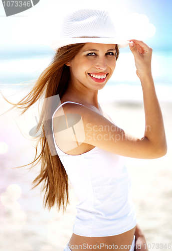 Image of Smiling woman with white hat at the beach