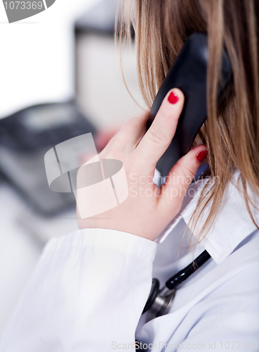Image of Back shot of a female doctor over a phone call