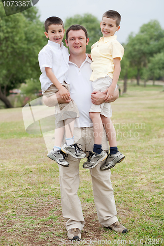 Image of father carrying his two son in his hands