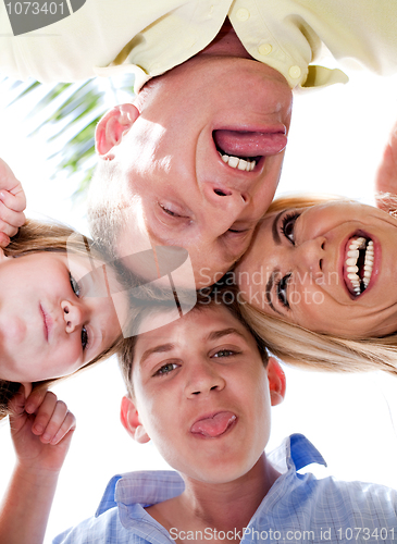 Image of Joyful family making weird faces in huddle