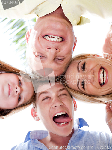 Image of Happy family joining their heads together and moking fun