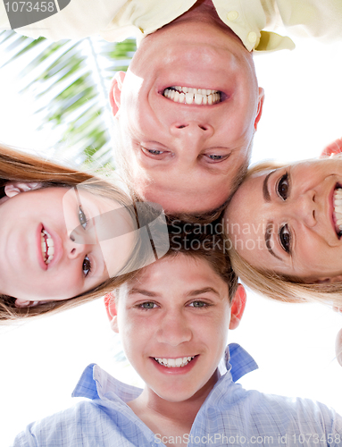 Image of Happy family smiling and joining their heads together