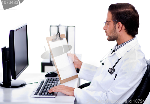 Image of Young ethnic doctor looking at medical report deeply