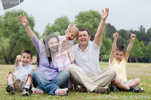 Image of Happy family of five having fun by raising hands