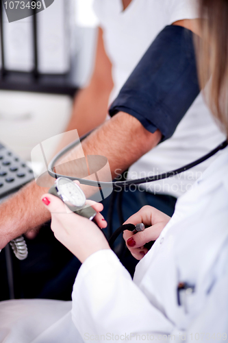 Image of Female doctor checking blood pressure