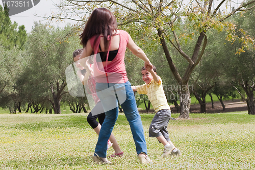 Image of Back shot of a family of three playing