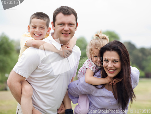 Image of Smiling couple carrying kids on their back