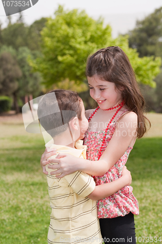Image of Brother and sister affectionatly hugging