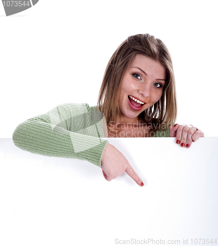 Image of Happy beautiful woman pointing out the blank white board