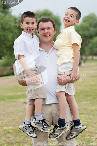 Image of Close up shot of curious father carrying his sons in his both hands