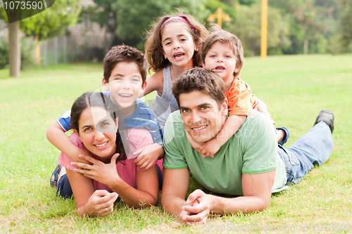 Image of Happy family lying in the park