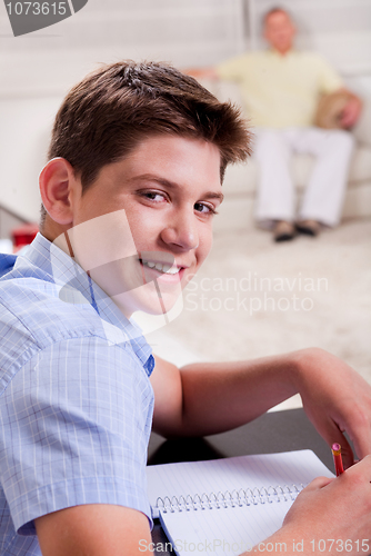 Image of Young boy in focus, studying and smiling at camera