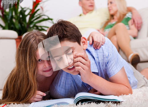 Image of Kids studying with family in the background