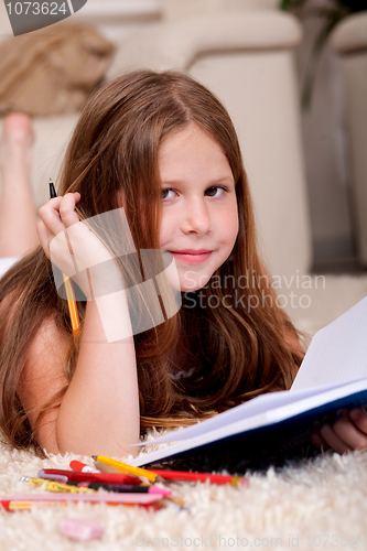 Image of Closeup of cute little girl doing her homework