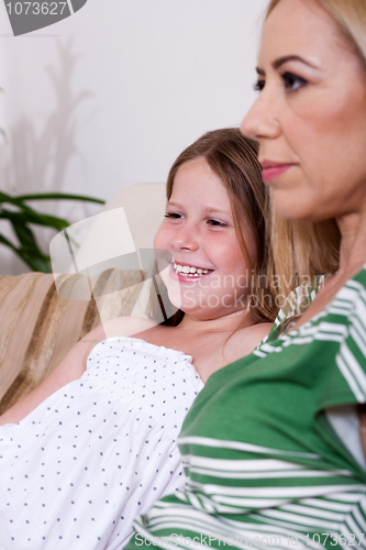 Image of Mother and daughter sitting together on couch