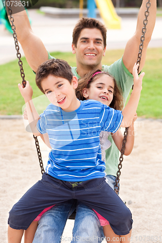 Image of Father and children enjoying swing ride