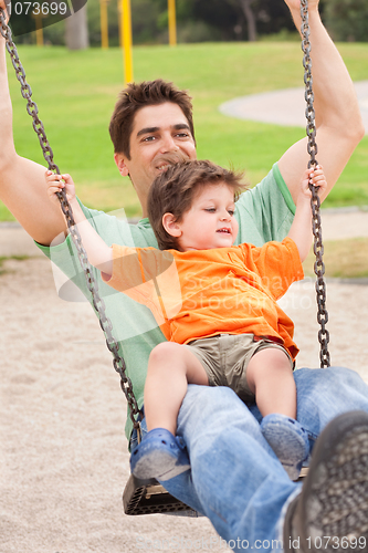 Image of Father enjoying swing ride with his son