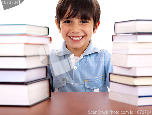 Image of School boy surrounded by books