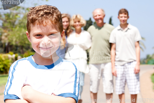 Image of Young cute boy in focus with family in the background