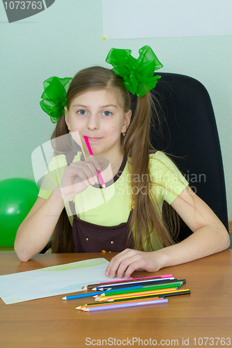 Image of Girl sitting at a table with pencils