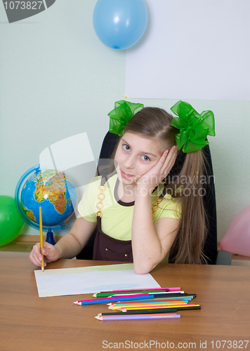 Image of Girl sitting at a table with pencils