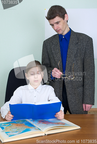 Image of Tutor and schoolgirl with book and atlas