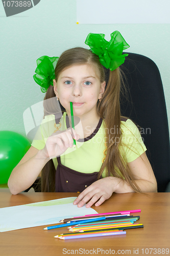 Image of Girl sitting at a table with pencils